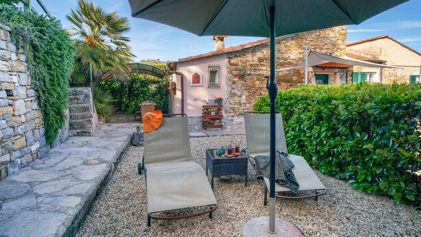 A patio with two lounge chairs, a table, and an umbrella. - Apartment 'Casa Cen' with Sea View, Private Terrace and Wi-Fi (Dolcedo)