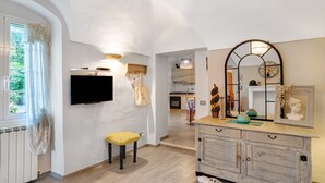 Un intérieur moderne avec un téléviseur à écran plat, un meuble en bois et un miroir doté d’un cadre décoratif.