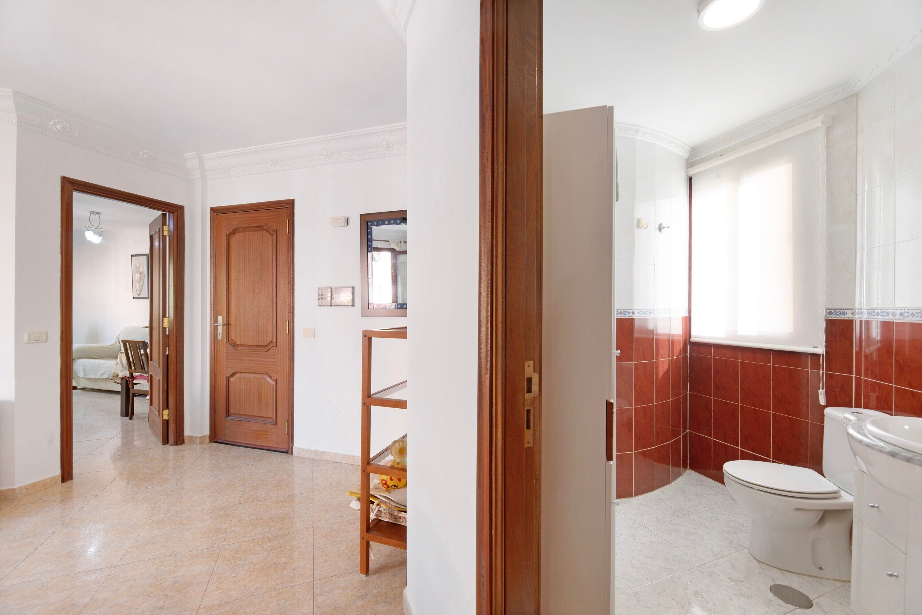 A bathroom with a toilet, a sink, and a shower area.