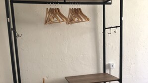 A metal-framed shelf unit with a woven basket and a small table.