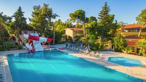A swimming pool with a water slide, lounge chairs, and a clear sky. - Dream Holiday Resort  (Burhaniye)