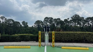 A green EV charging station with a white line marking the parking space. - 4BR Resort Home, 2 King Suites. Disney 9 min. Pools/Tennis/Pickleball/Gym/Sauna (Kissimmee)