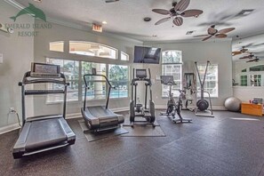 A gym with treadmills, elliptical machines, and free weights at Emerald Island Resort.