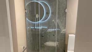 Ein modernes Badezimmer mit einer Duschkabine, einer Toilette und einem Waschbecken.