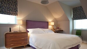A bedroom with a bed, nightstands, a dresser, and a chair. - Mackay Road - UK7451 (Dornoch)