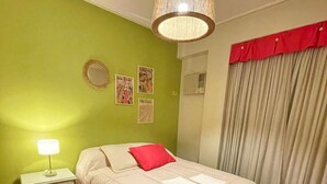 A bedroom with a bed, a nightstand, a lamp, a mirror, and a window with curtains. - Aparatemento de Lujo Paramont Tucumán (Tucuman)
