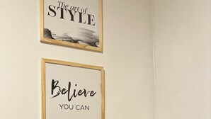 A kitchen area with a coffee maker, a thermos, and a jar of sugar on the counter. There are two motivational posters on the wall. - Aparatemento de Lujo Paramont Tucumán (Tucuman)