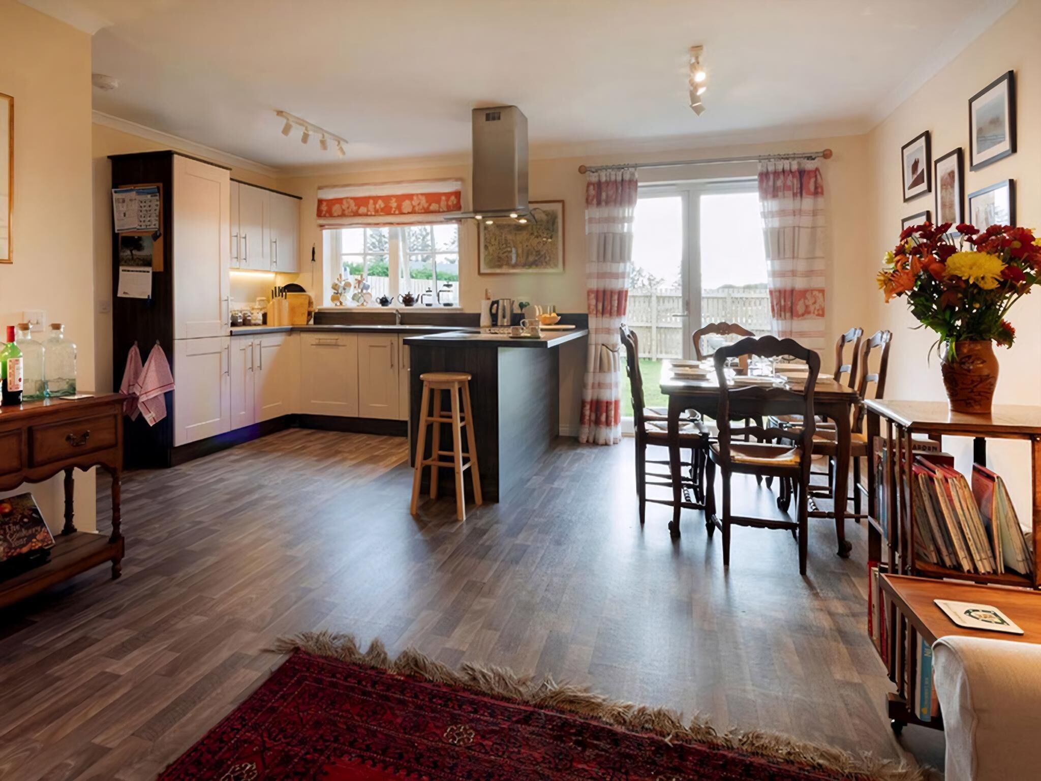 A spacious kitchen with wooden cabinets, a central island, and a dining area with a table and chairs.