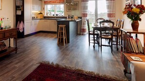 Una cocina amplia con armarios de madera, una isla central y un comedor con mesa y sillas.