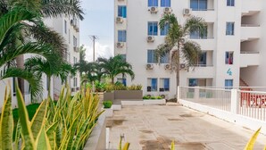 A multi-story building with balconies, air conditioning units, and a gated entrance. - Covenas Refugio de Familia junto al Mar (Coveñas)