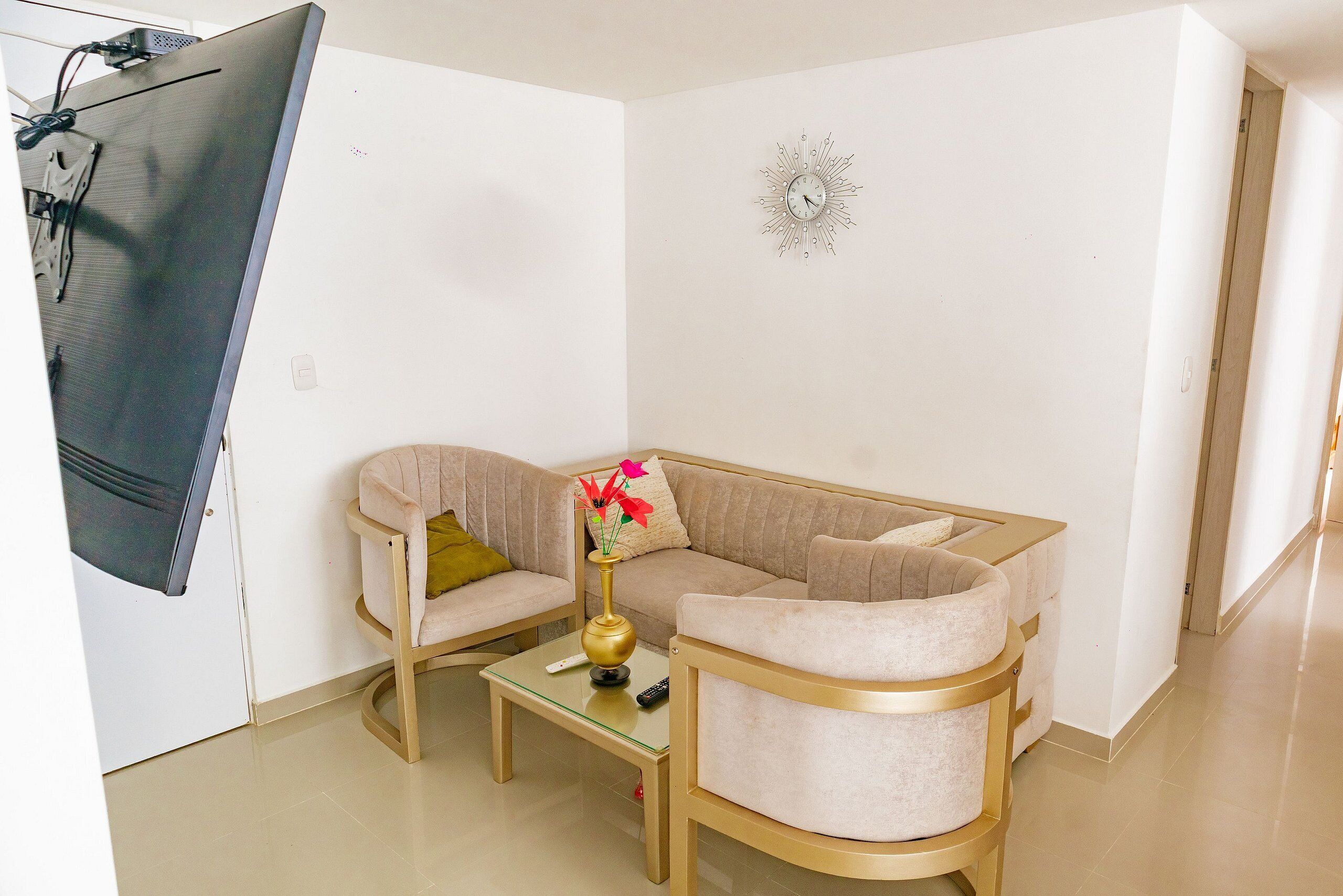 A modern living room with a beige sofa, a glass coffee table, and a decorative vase.