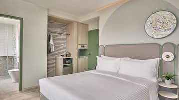 Un dormitorio moderno con una cama grande, un vestidor, zona de ducha y una obra de arte colgada en la pared.