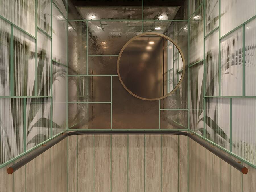 An elevator with a circular mirror, green-framed glass panels, and a terrazzo floor.