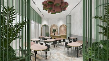 Un restaurant avec des tables et des chaises rondes, des plantes vertes et un sol en marbre.