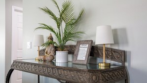 A decorative table with a glass top, a potted plant, two lamps, and a 'checkout instructions' sign.