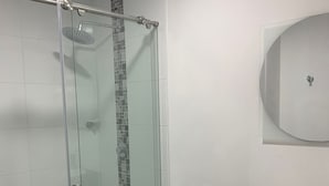 A modern bathroom with a glass shower enclosure, a white toilet, and a black vanity with a white sink. - «Javi's house: explore the charm of Cartagena (Cartagena de Indias)