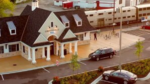 Et motel med en midterindgang, parkeringsplads og udsigt til gaden med en cykel.