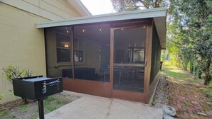 Un patio couvert avec une porte-fenêtre coulissante, un sol en béton et une boîte aux lettres.