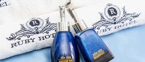 Two bottles of shower gel and shampoo on a white towel with 'Ruby Hotel' branding.
