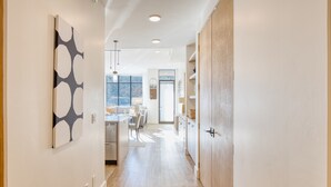 Una cucina moderna con mobili in legno, un'area pranzo con tavolo e sedie, e vista sull'esterno attraverso ampie finestre.