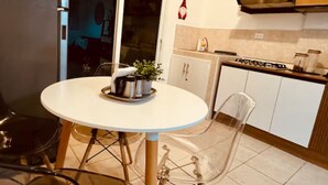 A compact kitchen with a round table, chairs, and a stove. - Charming 2-bedroom house in Santa Ana with WiFi and AC (Santa Ana)