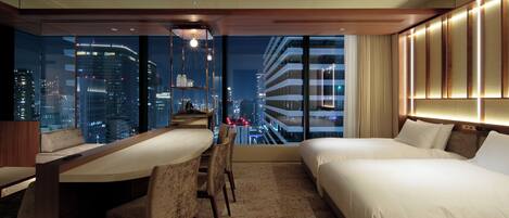 Una habitación de hotel moderna con vistas a la ciudad, un área de comedor y una cama grande.