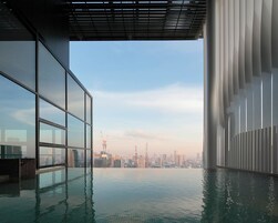 Piscina interna moderna com vista para a cidade, grandes janelas e design arquitetônico minimalista.
