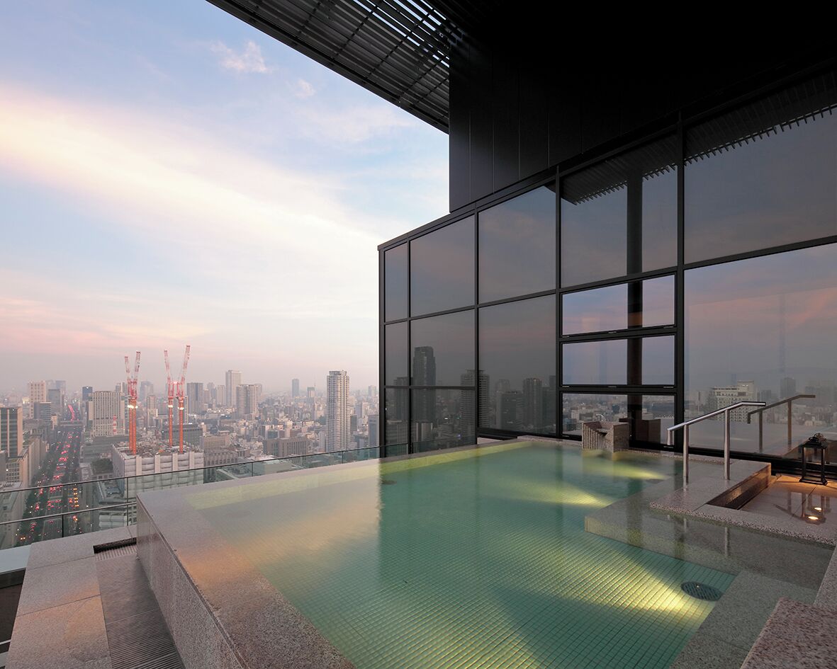 A rooftop infinity pool with a city view, large windows, and a modern architectural design.