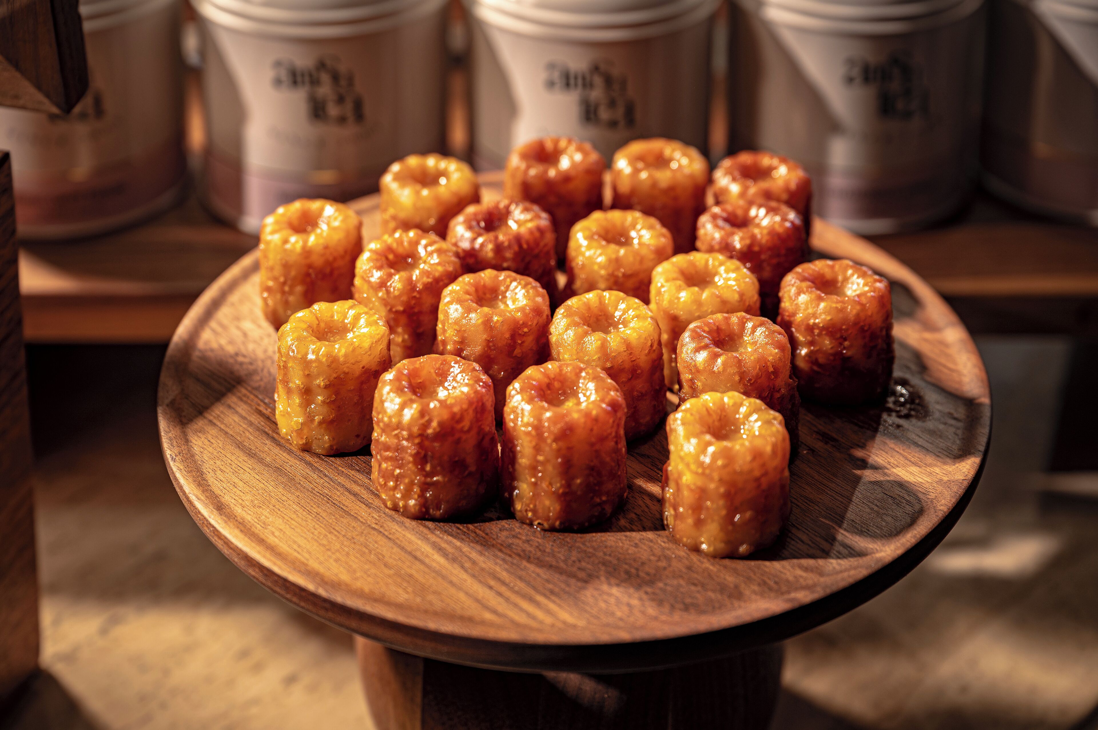 A wooden plate with glazed donuts on display.