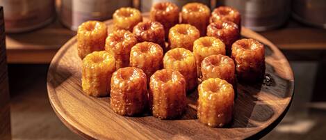 A wooden plate with glazed donuts on display.