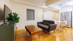 Una sala de estar moderna con un sofá, una mesa de centro y un mueble para televisión con una planta.