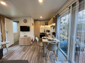 Een koelkast, een oven, kookgerei, borden en bestek