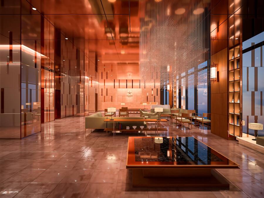 A modern lobby with a central seating area, glass partitions, and a large water feature.