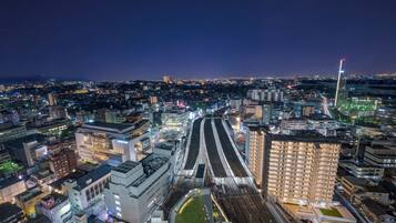 A nighttime cityscape with a prominent train station and surrounding buildings.
