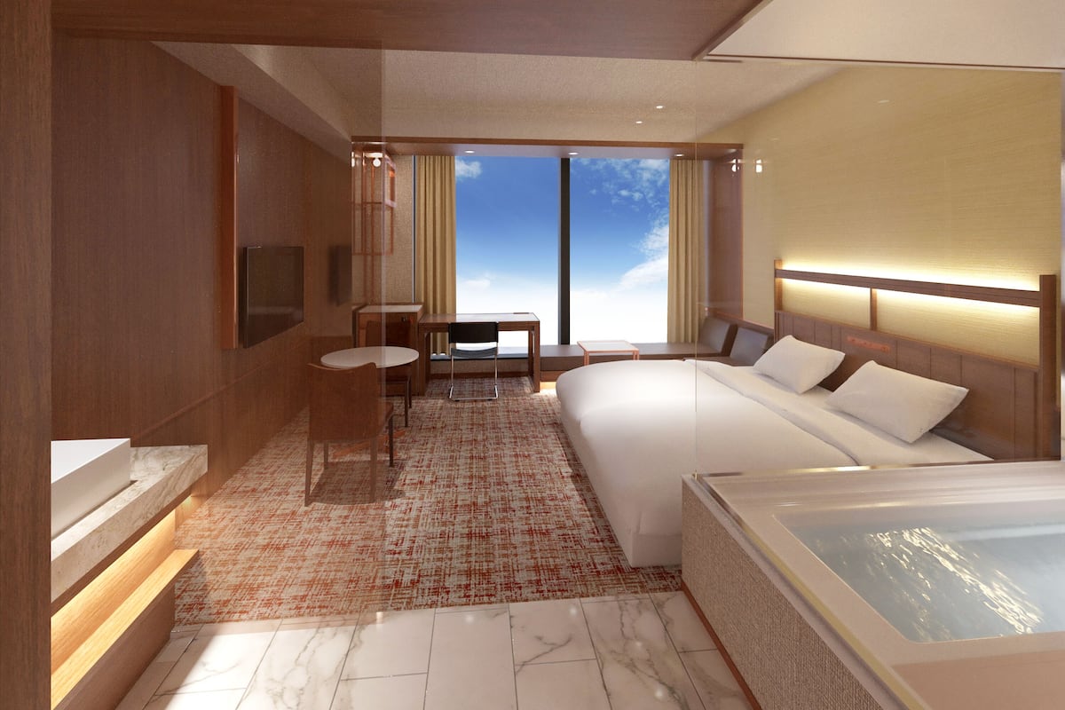 Een moderne hotelkamer met een groot bed, een zithoek met een tafel en stoelen, een badkuip en een groot raam met uitzicht op de lucht.