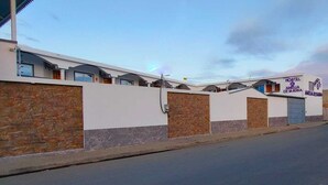 Un bâtiment moderne à la façade blanche, doté de nombreuses fenêtres et d’une enseigne indiquant qu’il s’agit d’une auberge de jeunesse.