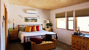 A bedroom with a wooden ceiling, a bed with multiple pillows, a nightstand, a dresser, and a window with blinds. - Entire home with privacy and views 10 mins to town 25mins to ski area  (El Prado)