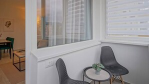 A modern room with a large window, two chairs, a small table, and a potted plant. - Mountain Hideaway w. Netflix and Mountain View (Brașov)