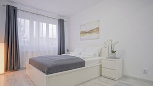 A modern bedroom with a bed, bedside table, and a wall-mounted artwork. - Mountain Hideaway w. Netflix and Mountain View (Brașov)
