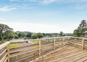 Une terrasse en bois offrant une vue sur un quartier résidentiel, avec des maisons et une route.