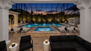 A pool area with lounge chairs, a hot tub, and a view of the sunset. - Mansion at Reunion | 11BR Luxe Stay w/ Private Pool, Theater, Arcade, and Themed Rooms near Disney (Kissimmee)