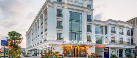 Un hotel de varios pisos con un diseño arquitectónico clásico, que cuenta con balcones y ventanas amplias.