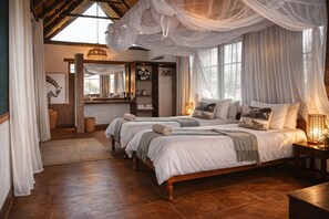 A bedroom with two beds, a large window, and a rustic ceiling. - Thornicroft Lodge (South Luangwa National Park)