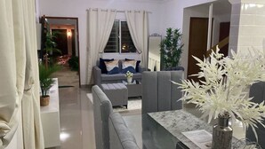 Un salon moderne avec un canapé gris, une table basse et une plante en pot.