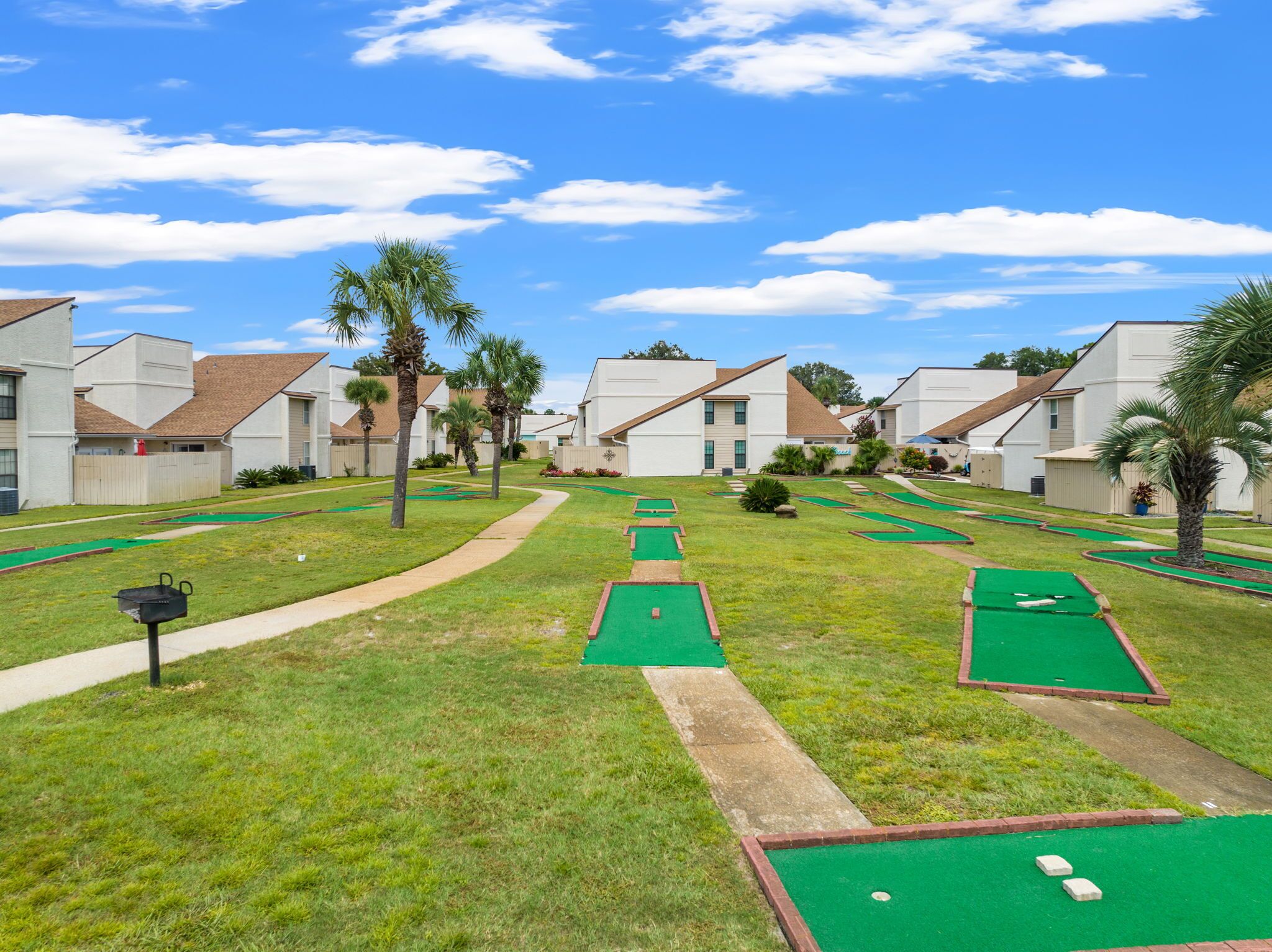 Un parcours de mini-golf entouré d’immeubles résidentiels, avec un ciel dégagé.