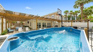 A backyard with a swimming pool, a basketball hoop, and a covered patio area. - A Wave From It All - Beach Cottage with Private Pool & Outdoor Area (Miramar Beach)