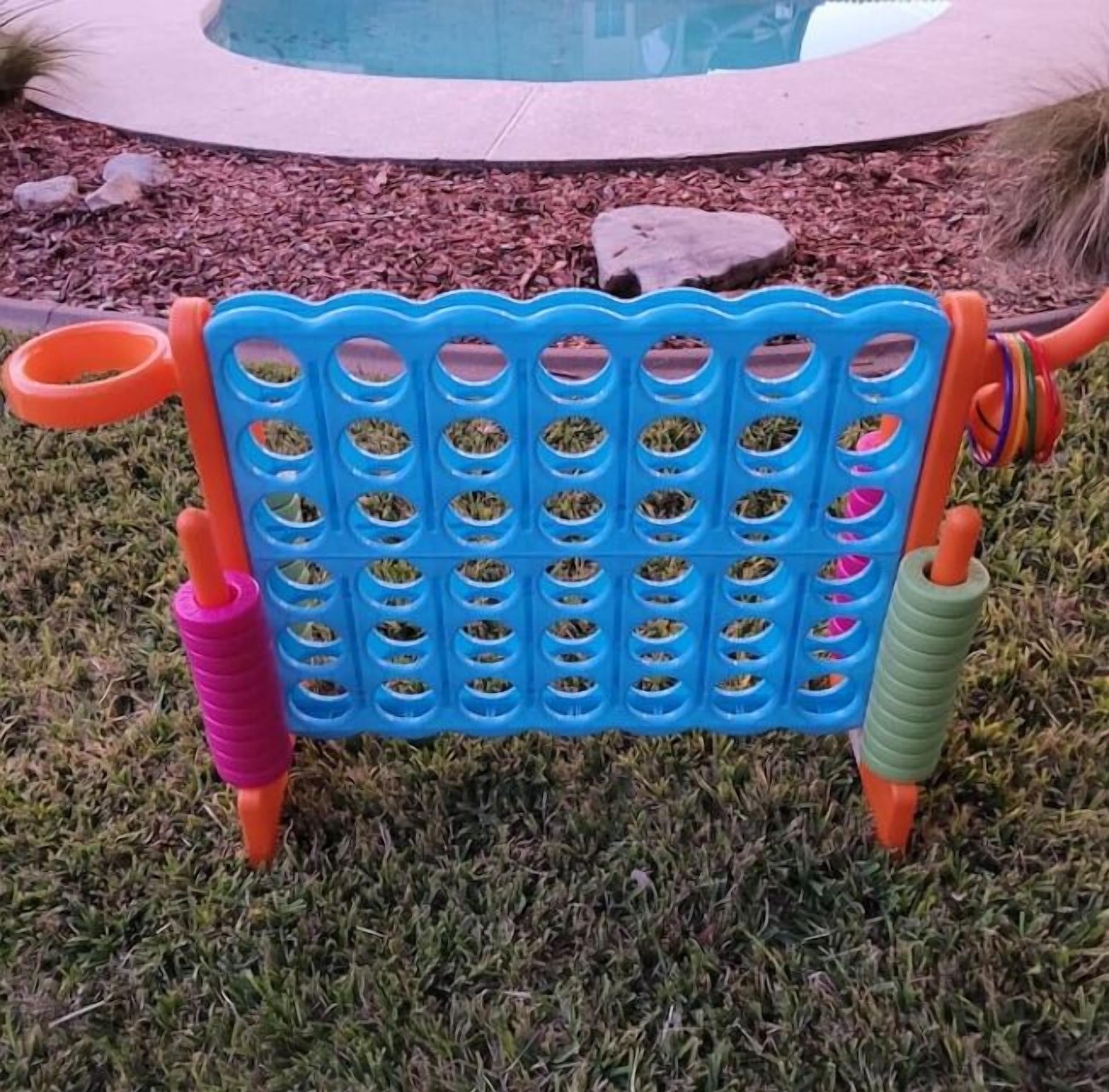 Un banco de plástico azul y naranja con varios agujeros para objetos, sobre césped.