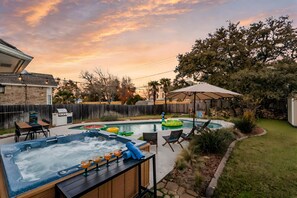 A backyard with a hot tub, pool, and outdoor seating area. - ATX Arcade, Theater, & Poolside Oasis! Pet & Kid Friendly! (Austin)
