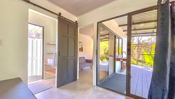 Quarto espaçoso com porta de vidro deslizante para um deck externo.