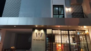 Un hotel con un letrero que dice 'We Resident Hotel' y un logotipo con la letra 'W'.